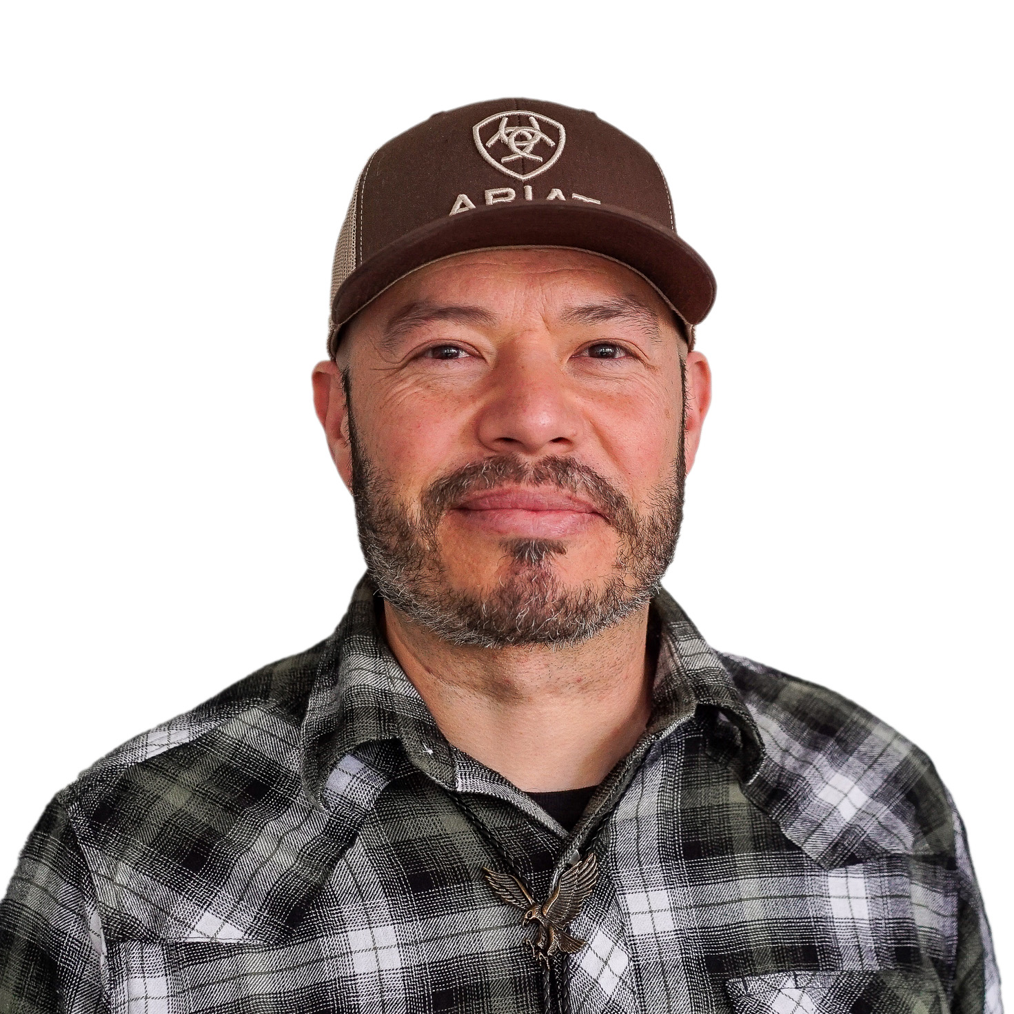 Jose smiling softly, wearing a plaid button-up shirt and brown baseball hat.