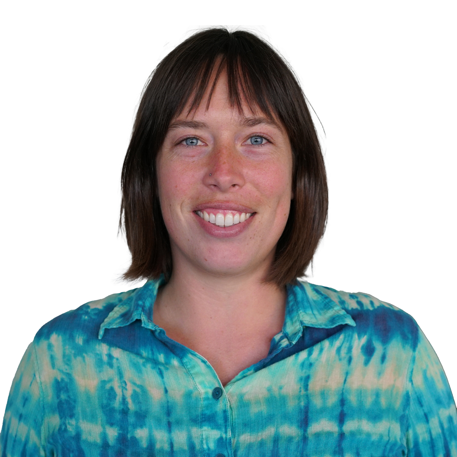 Mackenzie smiling and wearing a bright teal and blue tie-die button-up shirt